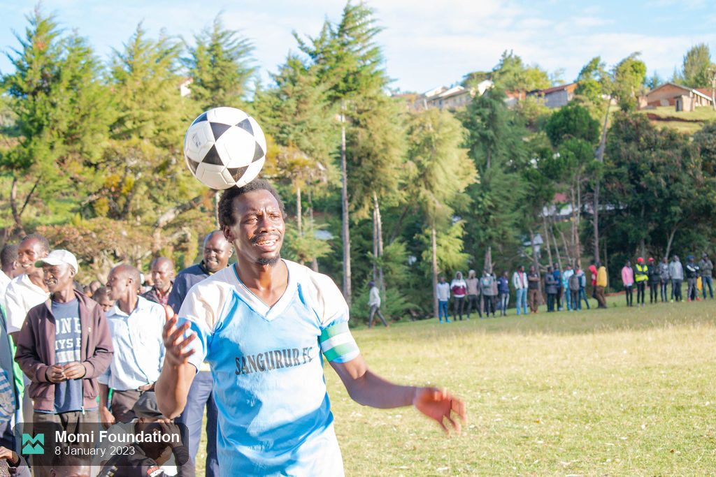 A player rises to head the ball in front of the crowd