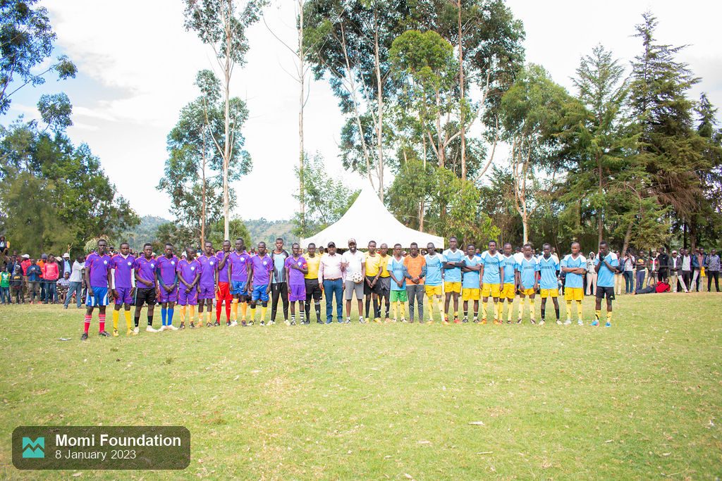 Football teams lined up before kick-off at the first MOMI football tournament, January 2023