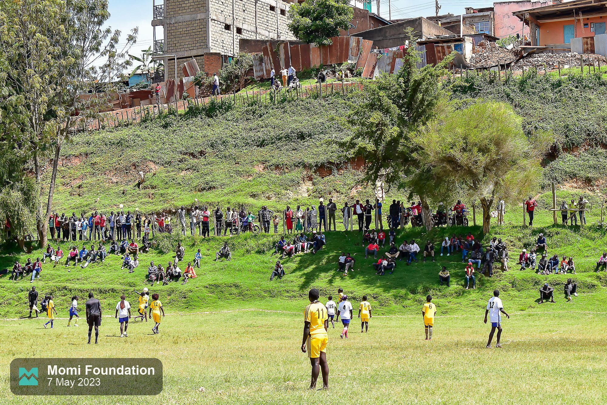 Fans on the hillside above the pitch at the second MOMI football tournament