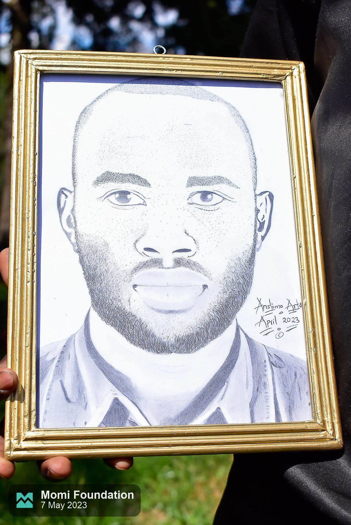 Close-up of a framed pencil portrait signed Anslimo Arts, April 2023