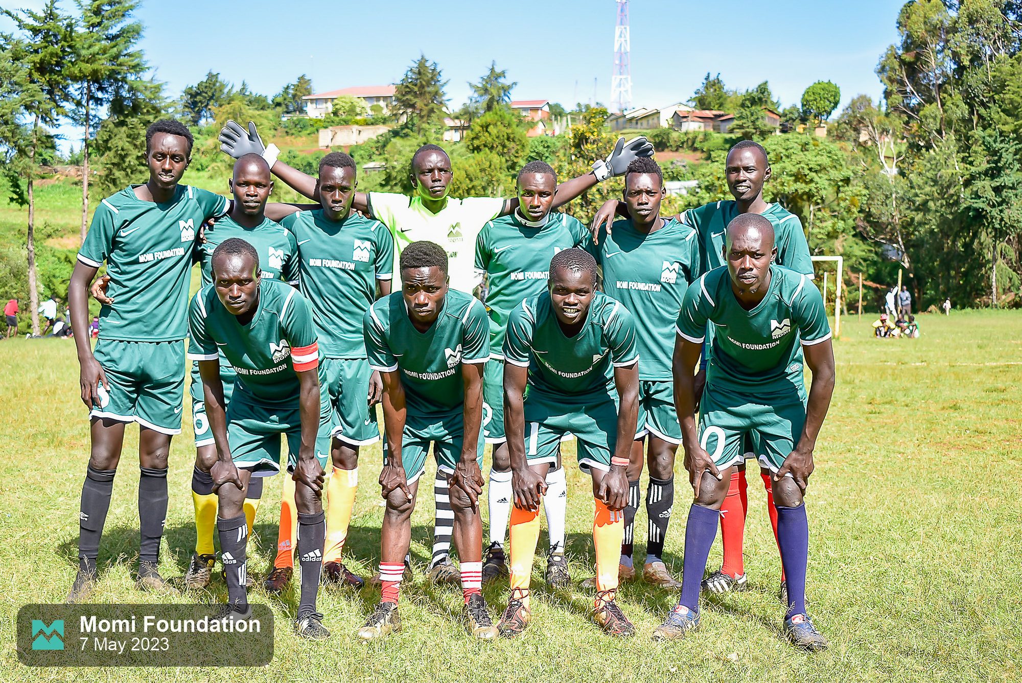 A football team in green kits posing for a team photo
