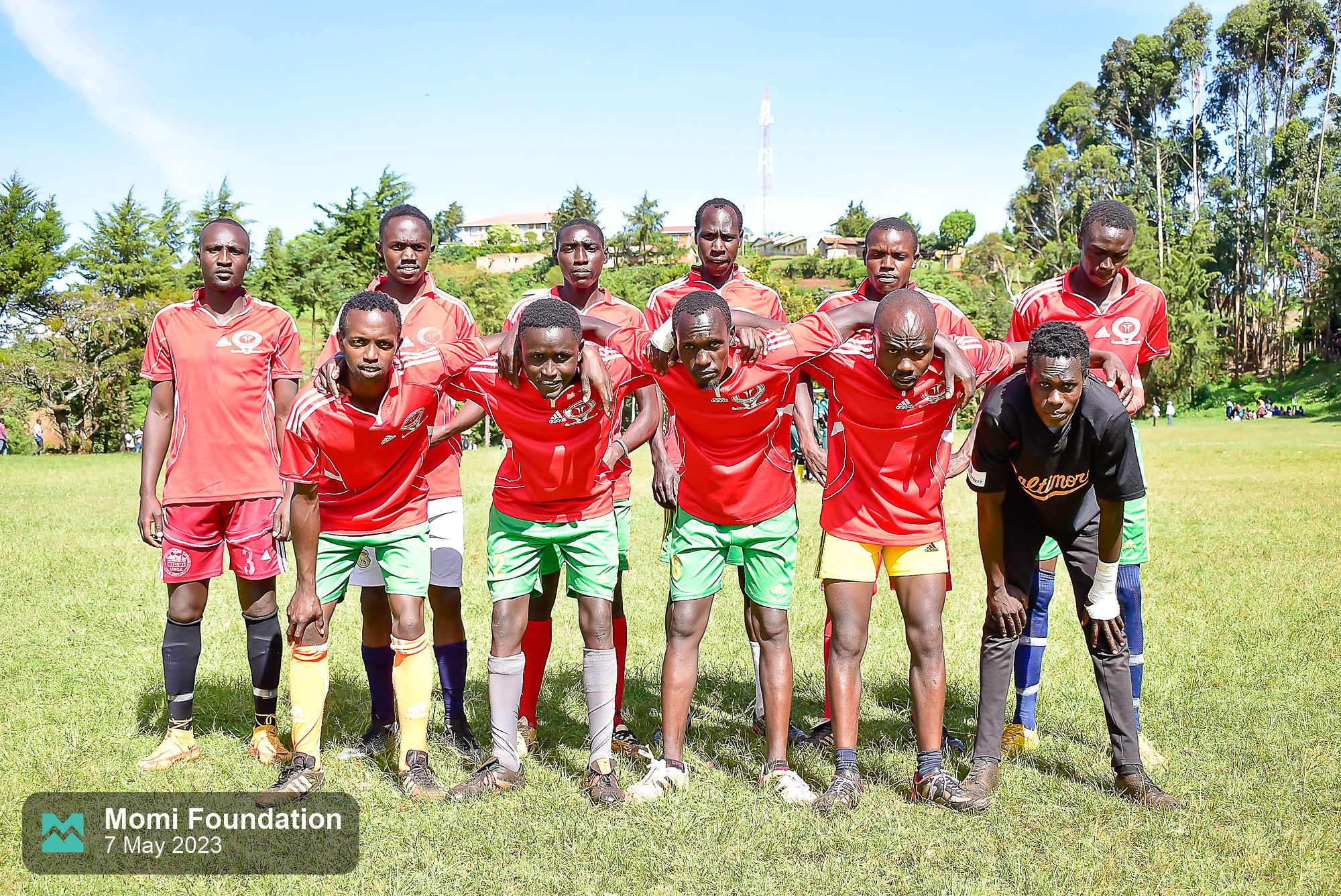 A team in red kits posing for a team photo before a match