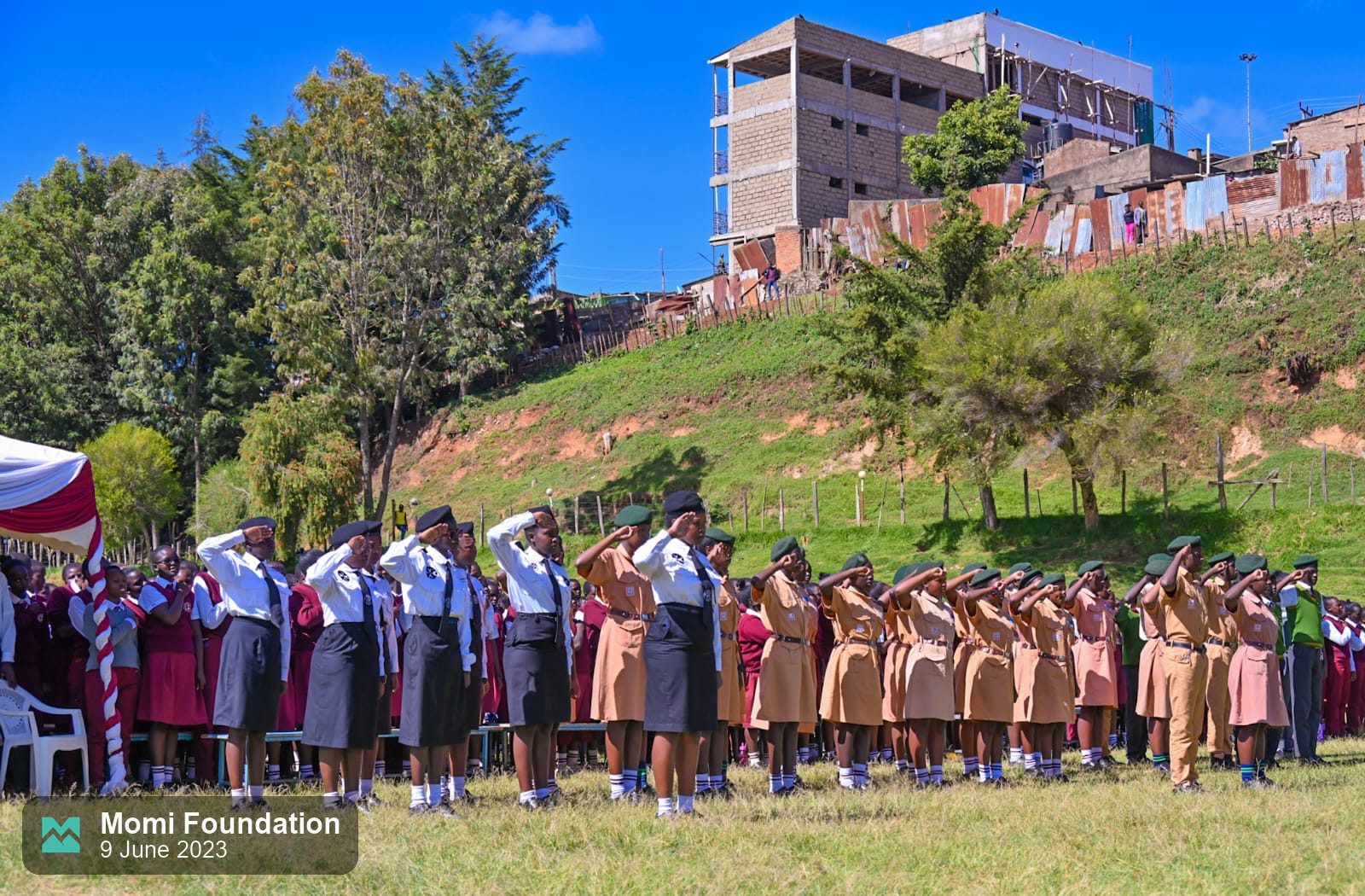 Rows of students in school uniform lined up across the field