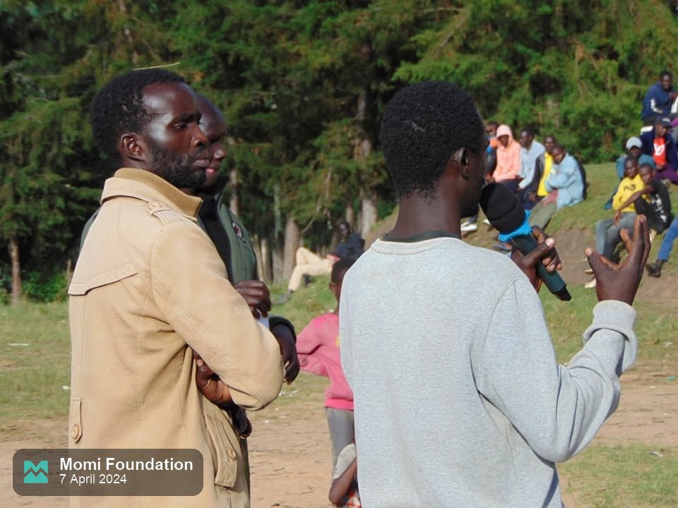 A Momi Foundation official addresses the crowd with a microphone