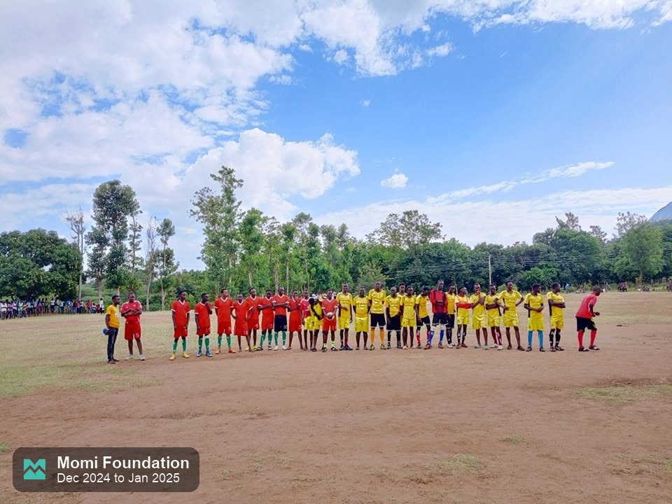 Teams lined up across the dirt pitch at kick-off